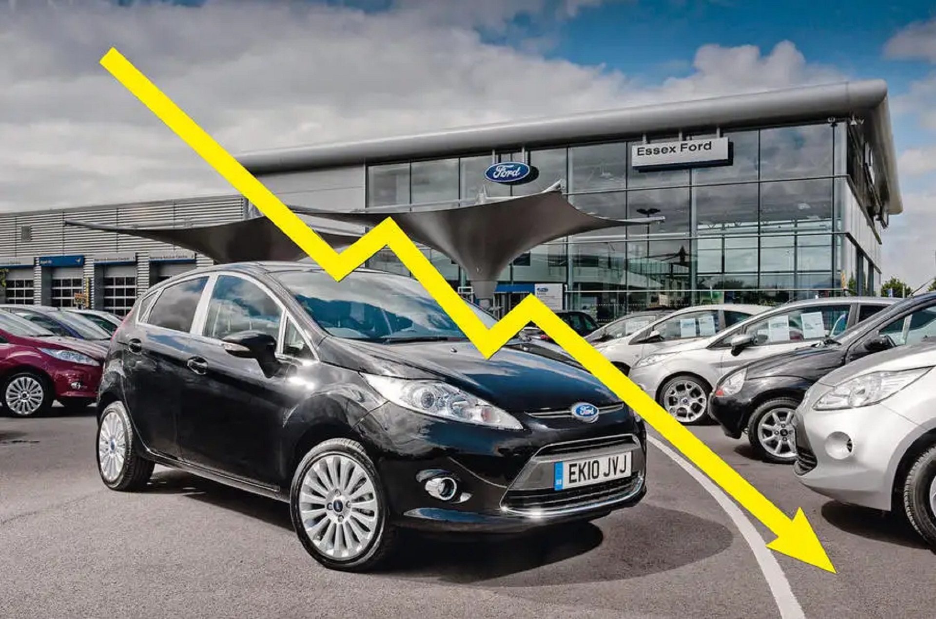 Image showing black Ford hatchback with downward pointing yellow arrow across it.