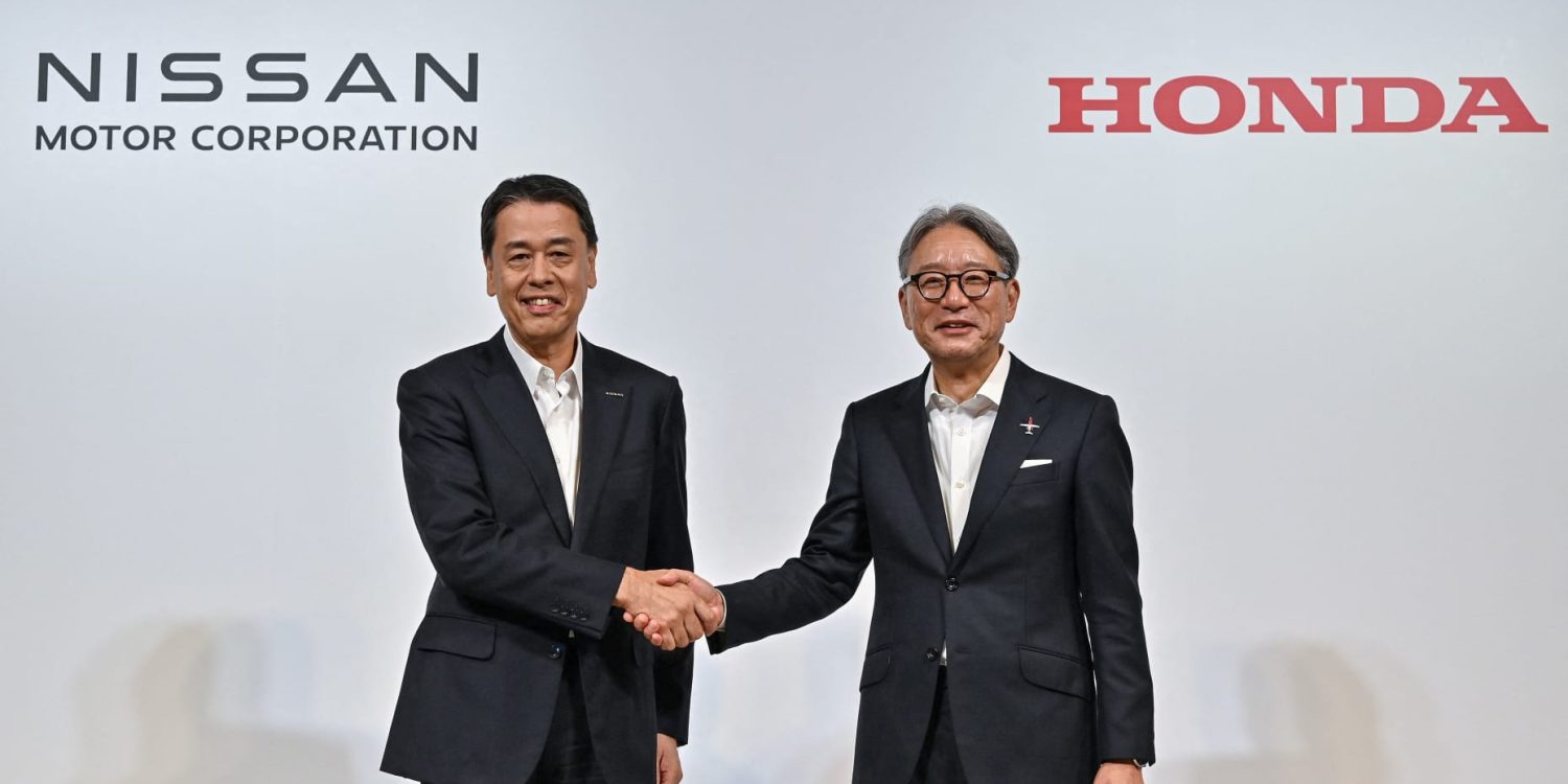 Nissan CEO Makoto Ushida and Honda CEO Toshihiro Mibe shaking hands