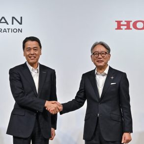 Nissan CEO Makoto Ushida and Honda CEO Toshihiro Mibe shaking hands