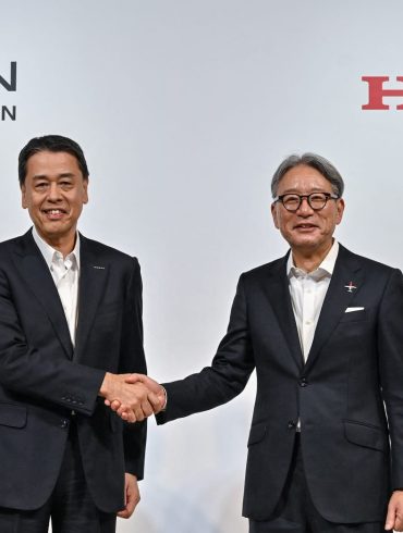 Nissan CEO Makoto Ushida and Honda CEO Toshihiro Mibe shaking hands